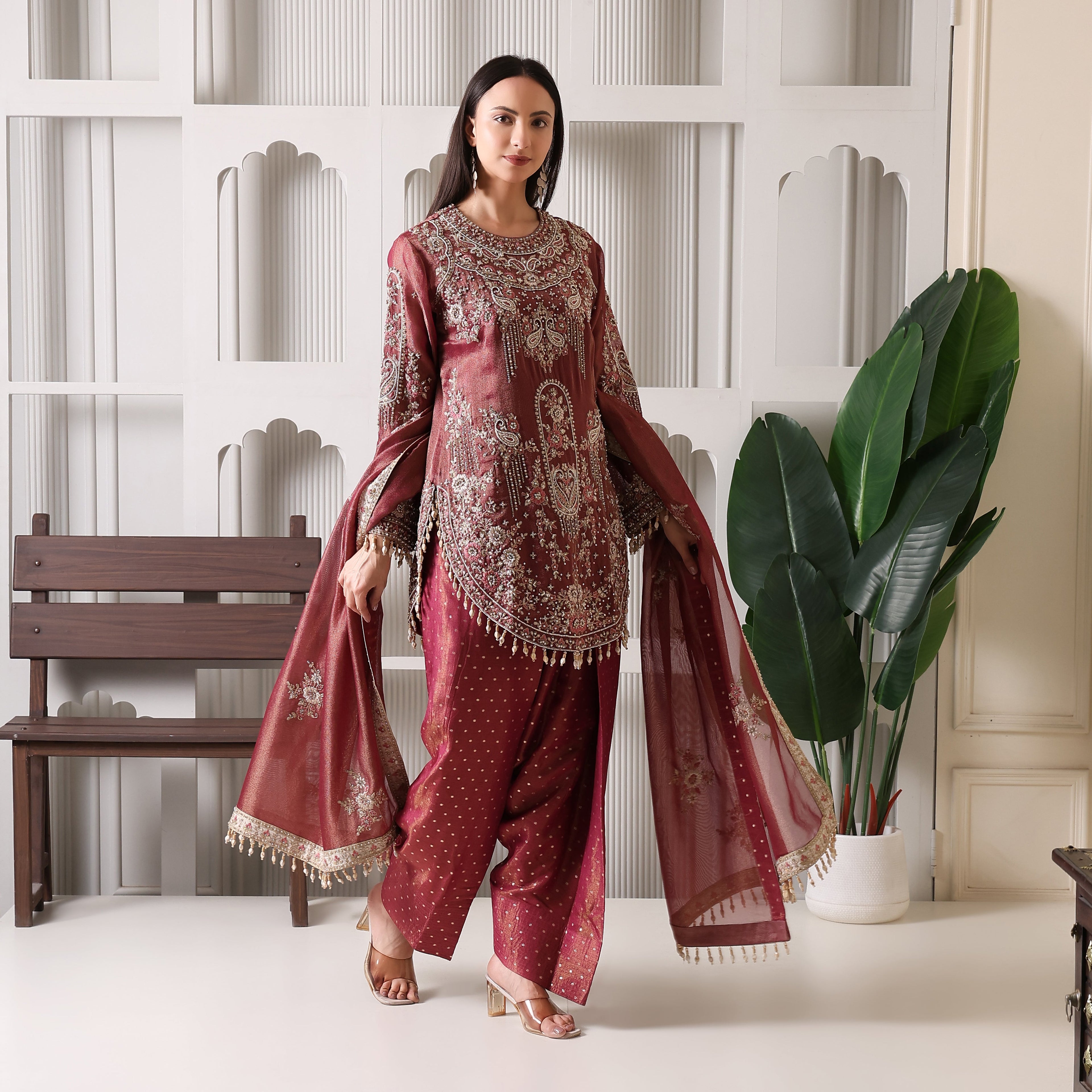 Woman wearing maroon embroidered ethnic suit with dupatta, luxury festive outfit indoors