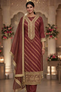 Woman wearing maroon and gold embroidered Anarkali suit with dupatta, festive ethnic wear