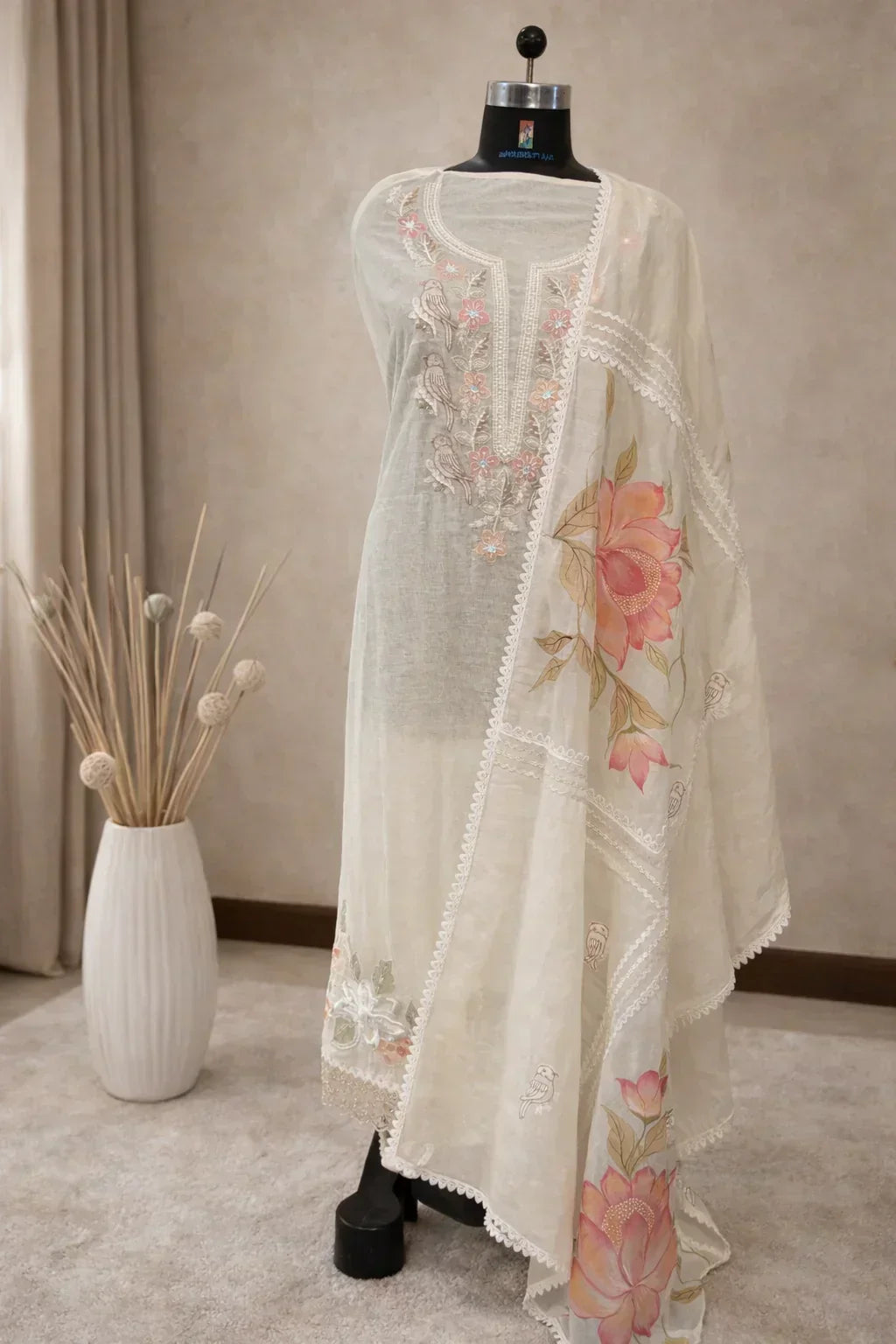 Ivory ethnic suit with floral and bird embroidery, sheer dupatta, displayed on mannequin