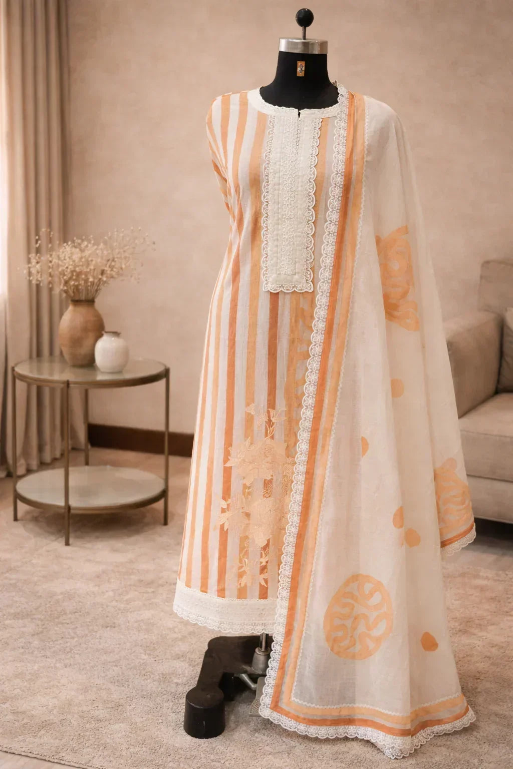 Pastel striped Anarkali suit with lace detailing and matching dupatta on mannequin