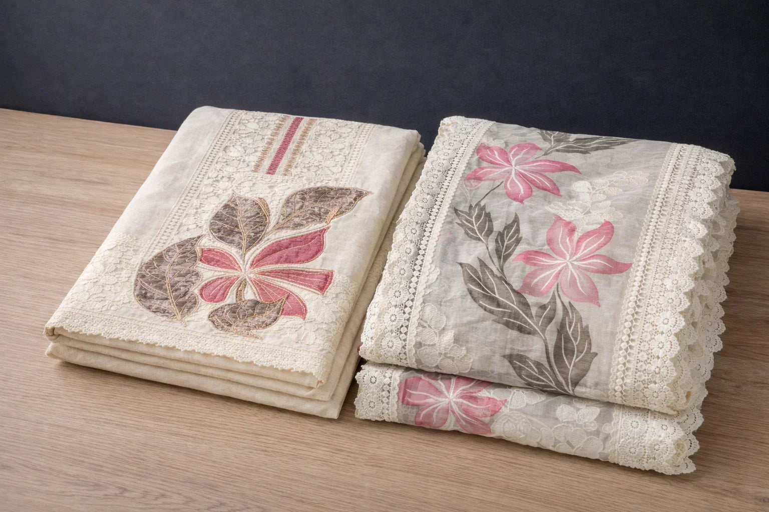 Folded ethnic fabric with floral embroidery and lace detailing in pink, beige, and cream tones