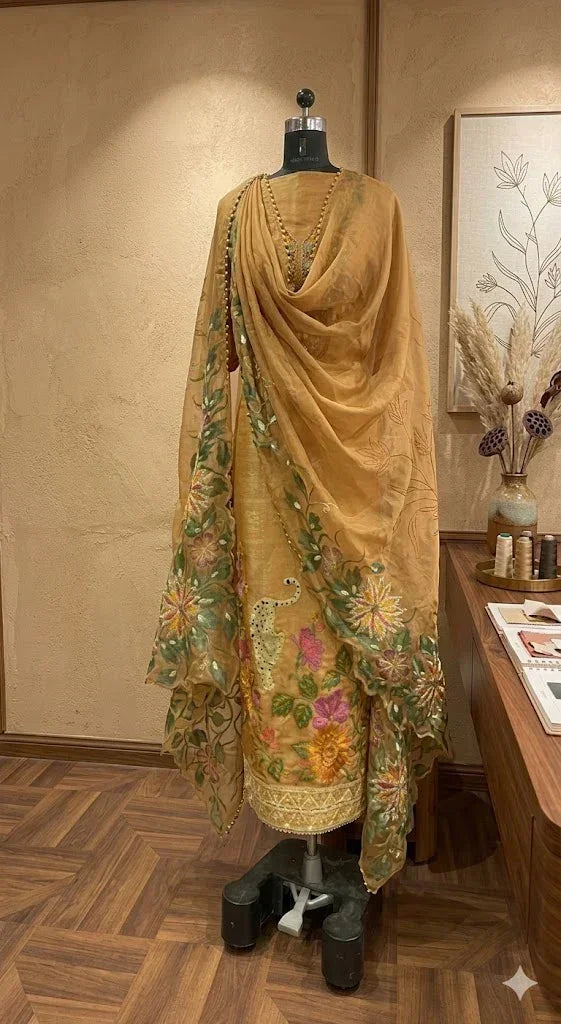 Beige embroidered ethnic suit with floral motifs and dupatta on mannequin in boutique setting