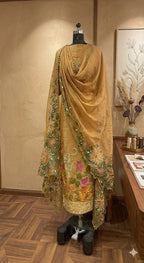 Beige embroidered ethnic suit with floral motifs and dupatta on mannequin in boutique setting