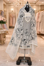 Grey ethnic suit with floral embroidered dupatta displayed on mannequin in a boutique