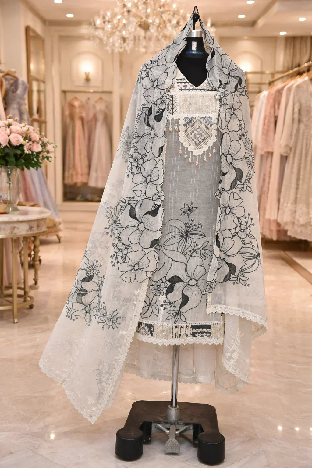 Grey ethnic suit with floral embroidered dupatta displayed on mannequin in a boutique