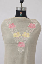 Beige ethnic fabric with pink and yellow floral embroidery on neckline, displayed on mannequin