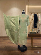 Pastel green embroidered ethnic suit set with dupatta displayed on mannequin in boutique