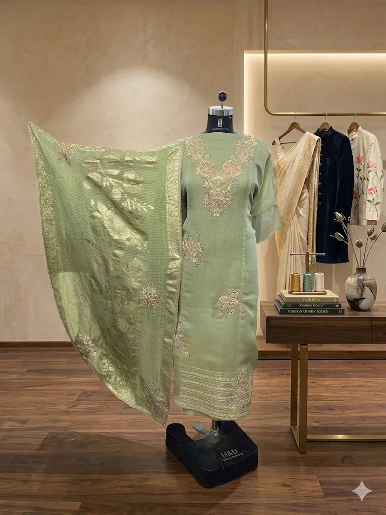 Pastel green embroidered ethnic suit set with dupatta displayed on mannequin in boutique