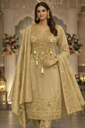 Woman wearing an elegant beige embroidered ethnic suit with dupatta, perfect for weddings.