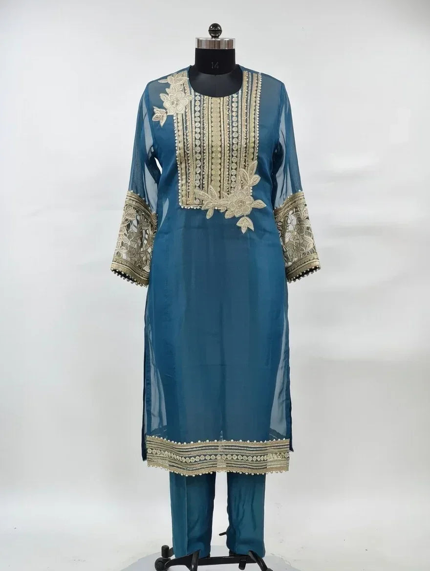 Blue ethnic suit with gold embroidery, sheer sleeves, and matching trousers on mannequin