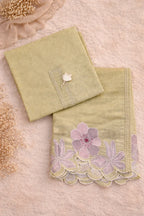 Pastel green ethnic fabric set with pink floral embroidery and lace detailing, flat lay