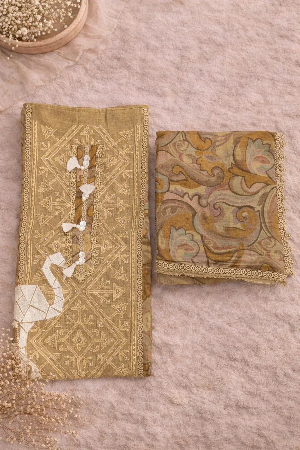 Embroidered ethnic fabric set with geometric and floral motifs in neutral tones, flat lay