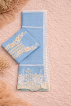 Flat lay of blue ethnic fabric set with floral embroidery and lace, ideal for festive wear.