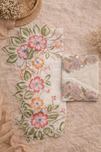 Floral embroidered fabric and folded dupatta in pastel colors on textured beige background
