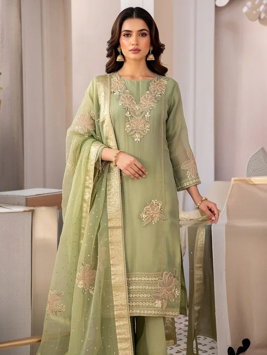 Woman wearing a pastel green embroidered Anarkali suit with dupatta, gold borders, festive ethnic wear