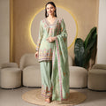 Woman in pastel green embroidered ethnic suit with matching dupatta and palazzo pants