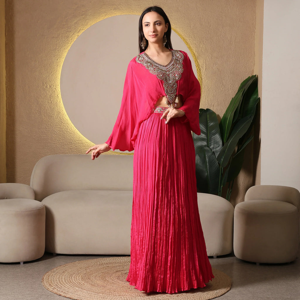 Woman wearing a bright pink ethnic designer outfit with embellished neckline, standing indoors