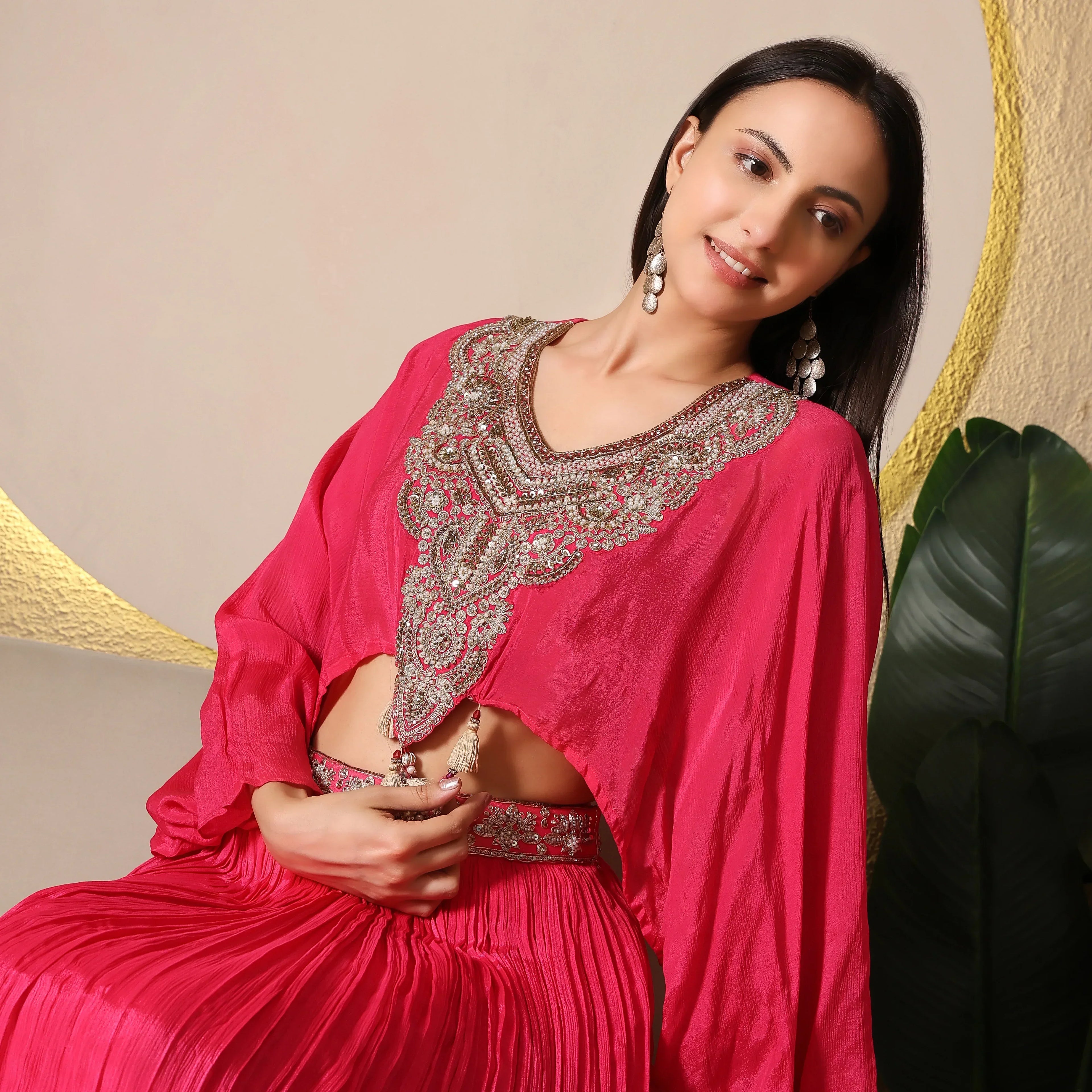 Woman in pink embellished ethnic outfit with statement earrings, ideal for festive occasions