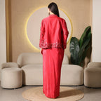 Woman in a red embellished ethnic suit posing indoors with modern decor