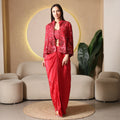 Woman in red embellished ethnic three-piece set with cape jacket, modern festive wear