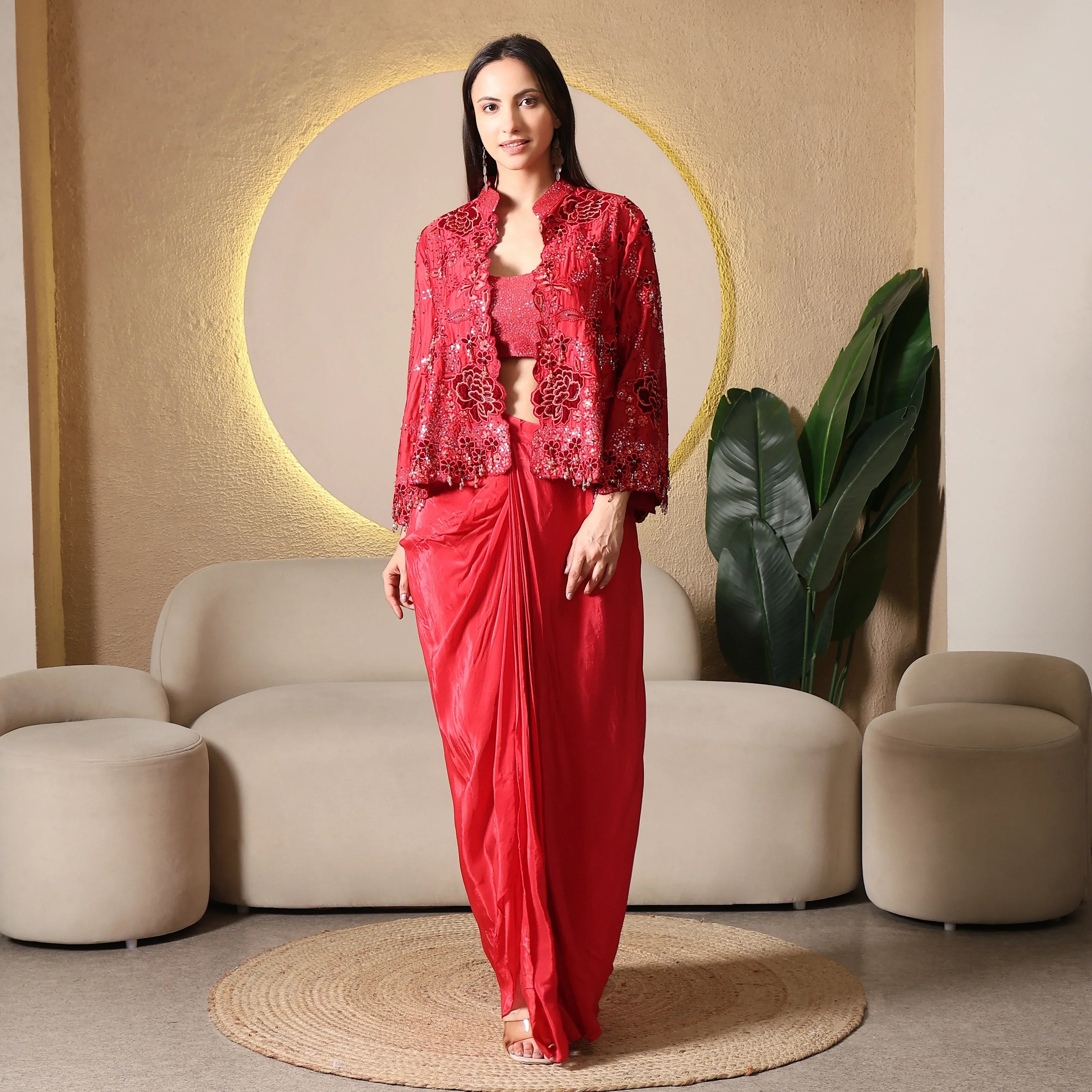 Woman in red embellished ethnic three-piece set with cape jacket, modern festive wear