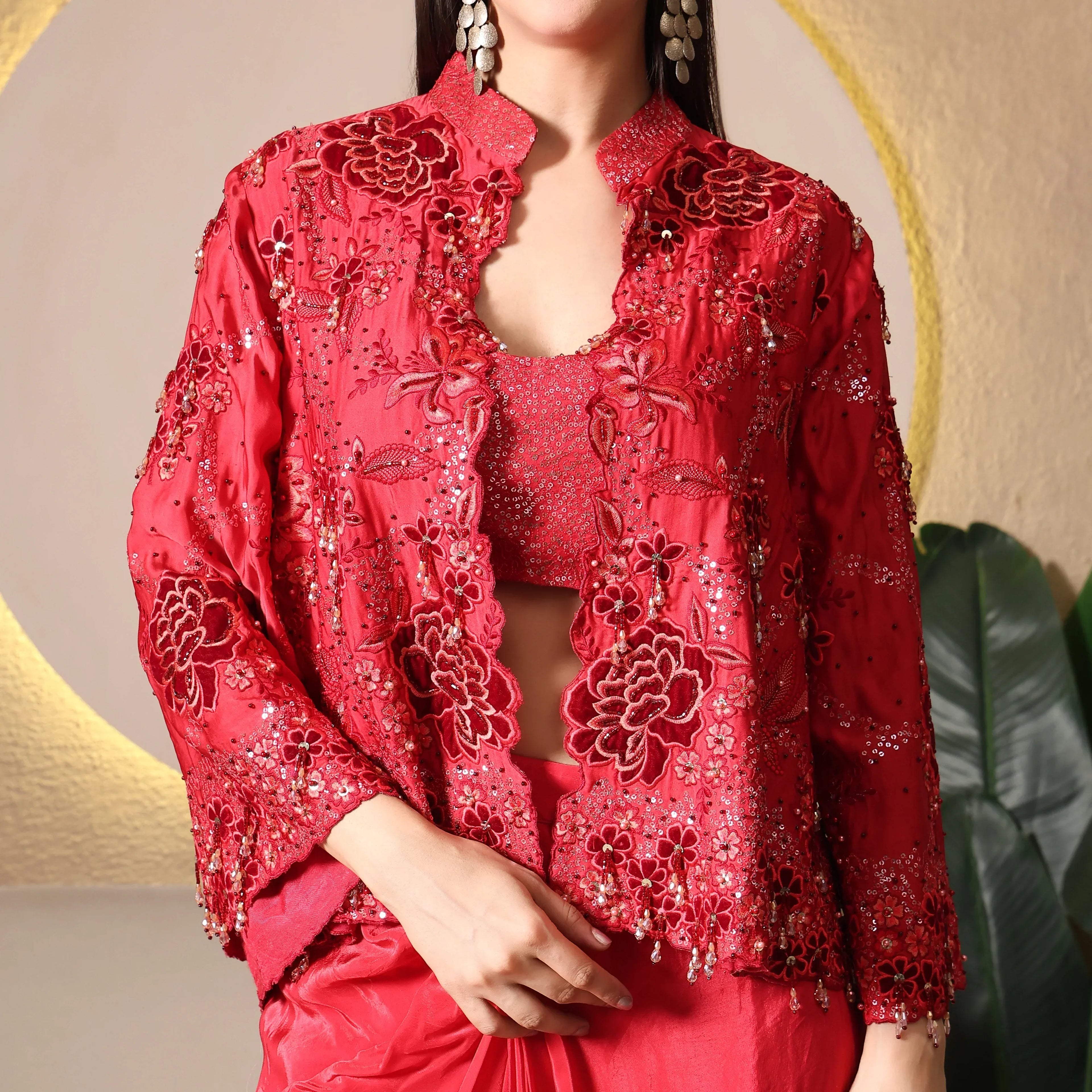 Woman wearing a red embroidered ethnic jacket with sequin floral detailing