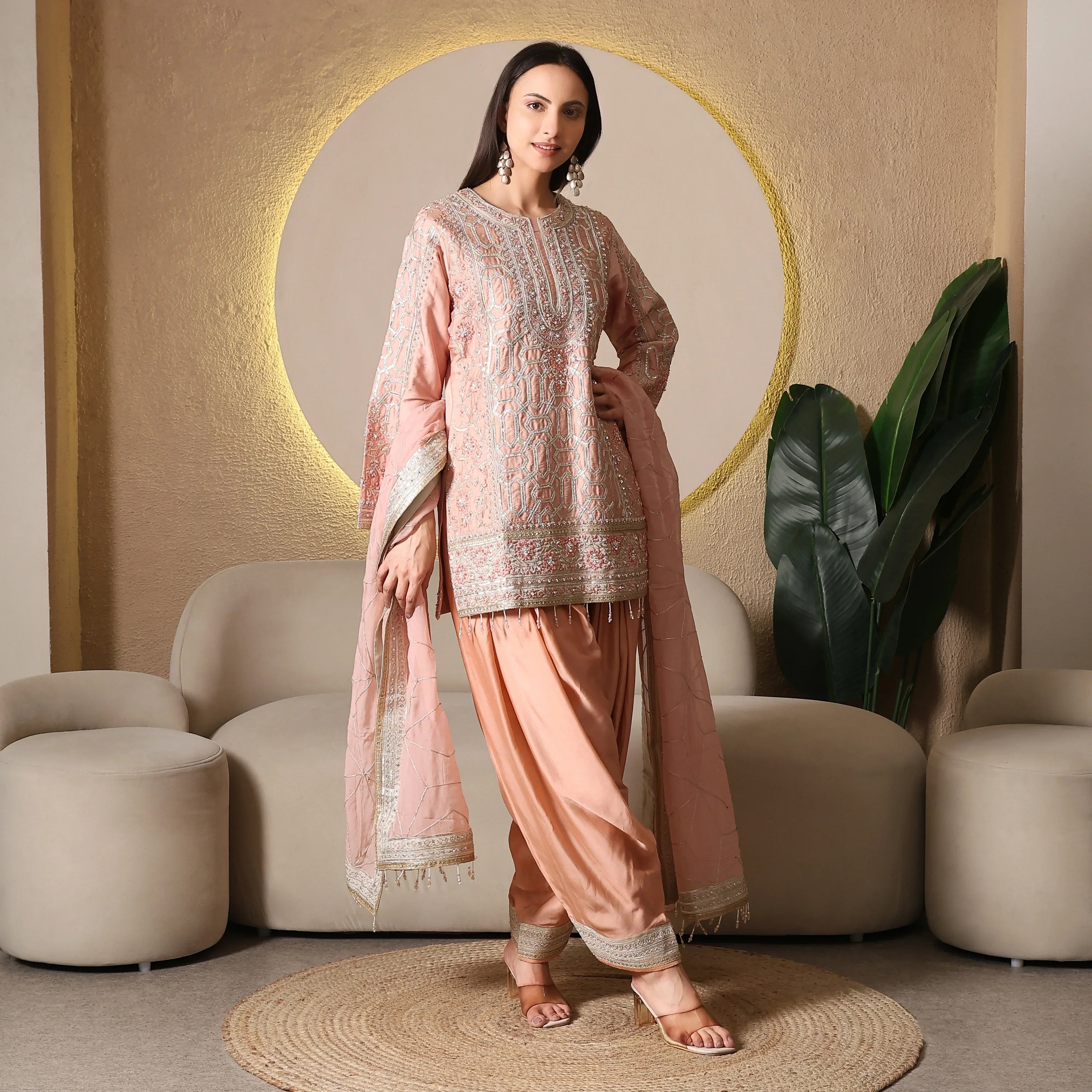 Woman in pastel pink embroidered ethnic suit with dupatta, ideal for festive or wedding wear