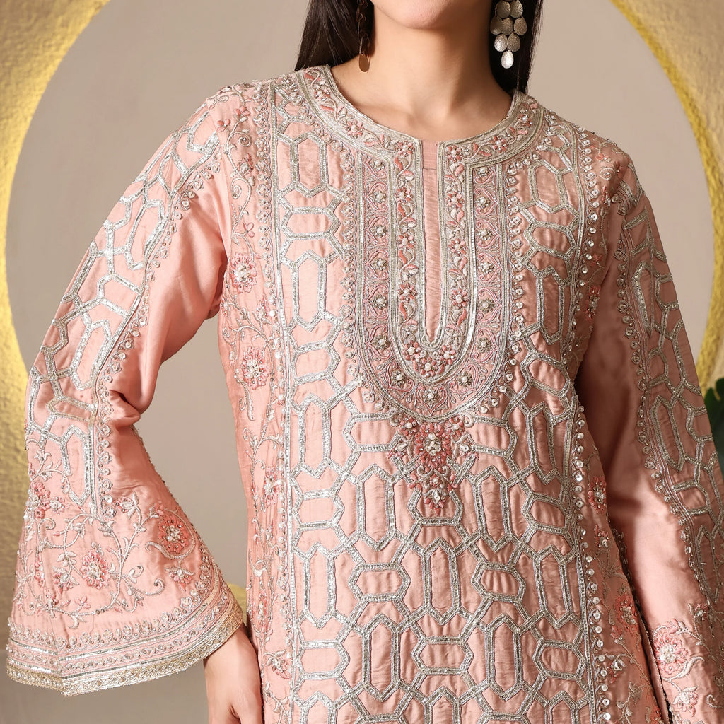 Woman wearing peach embroidered ethnic kurta with mirror and thread work, festive outfit