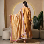 Woman wearing golden Banarasi Anarkali suit with embroidered dupatta, back view