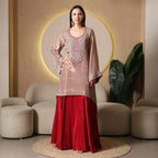 Woman in embroidered mauve kurta and red ethnic skirt, elegant festive outfit in modern living room