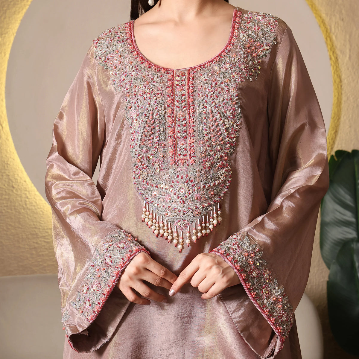 Woman wearing mauve ethnic kurta with intricate pink and silver embroidery, festive attire