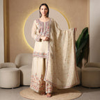 Woman in cream embroidered Anarkali suit and dupatta, festive ethnic wear indoors