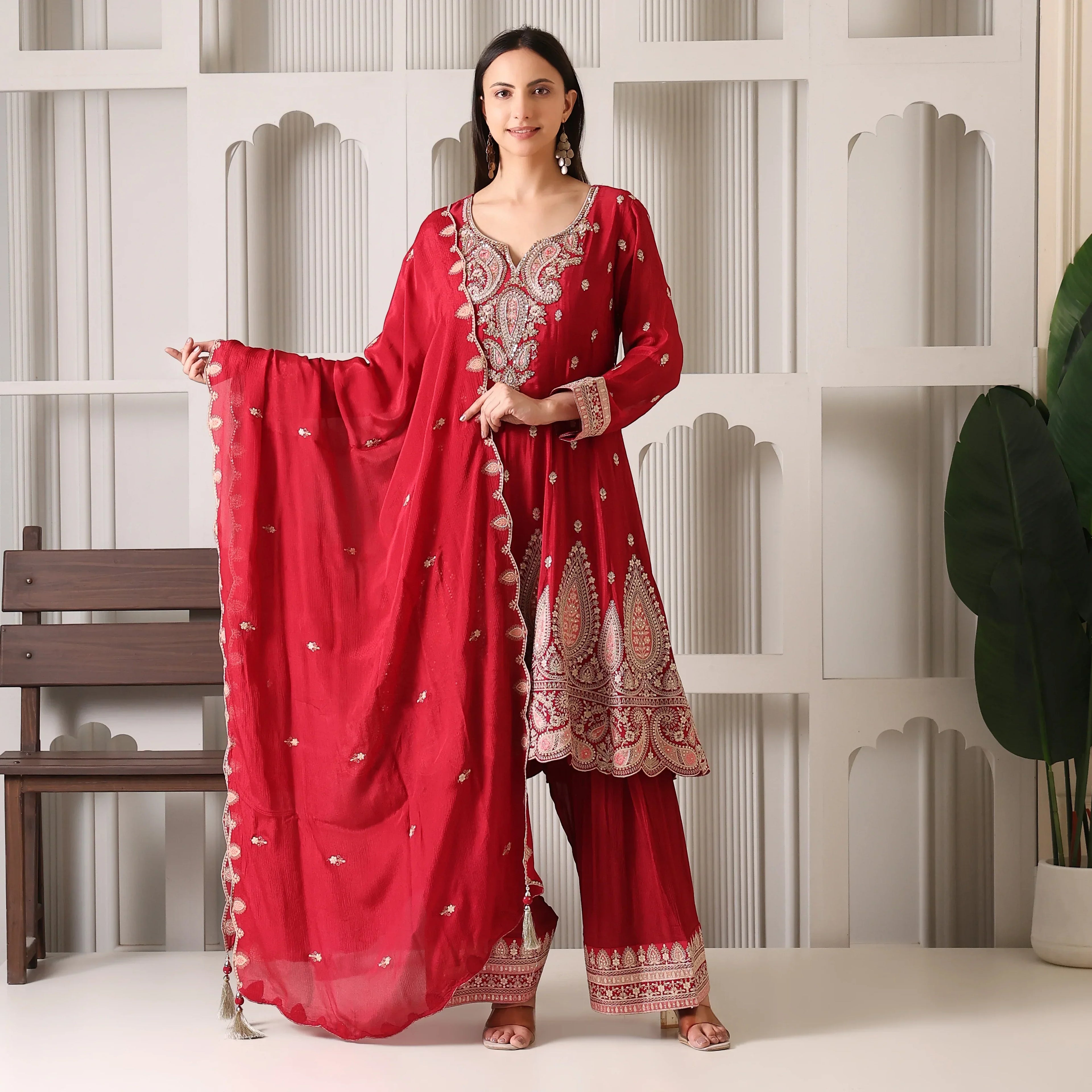 Woman wearing red Banarasi Anarkali suit with dupatta, ethnic embroidery, festive attire