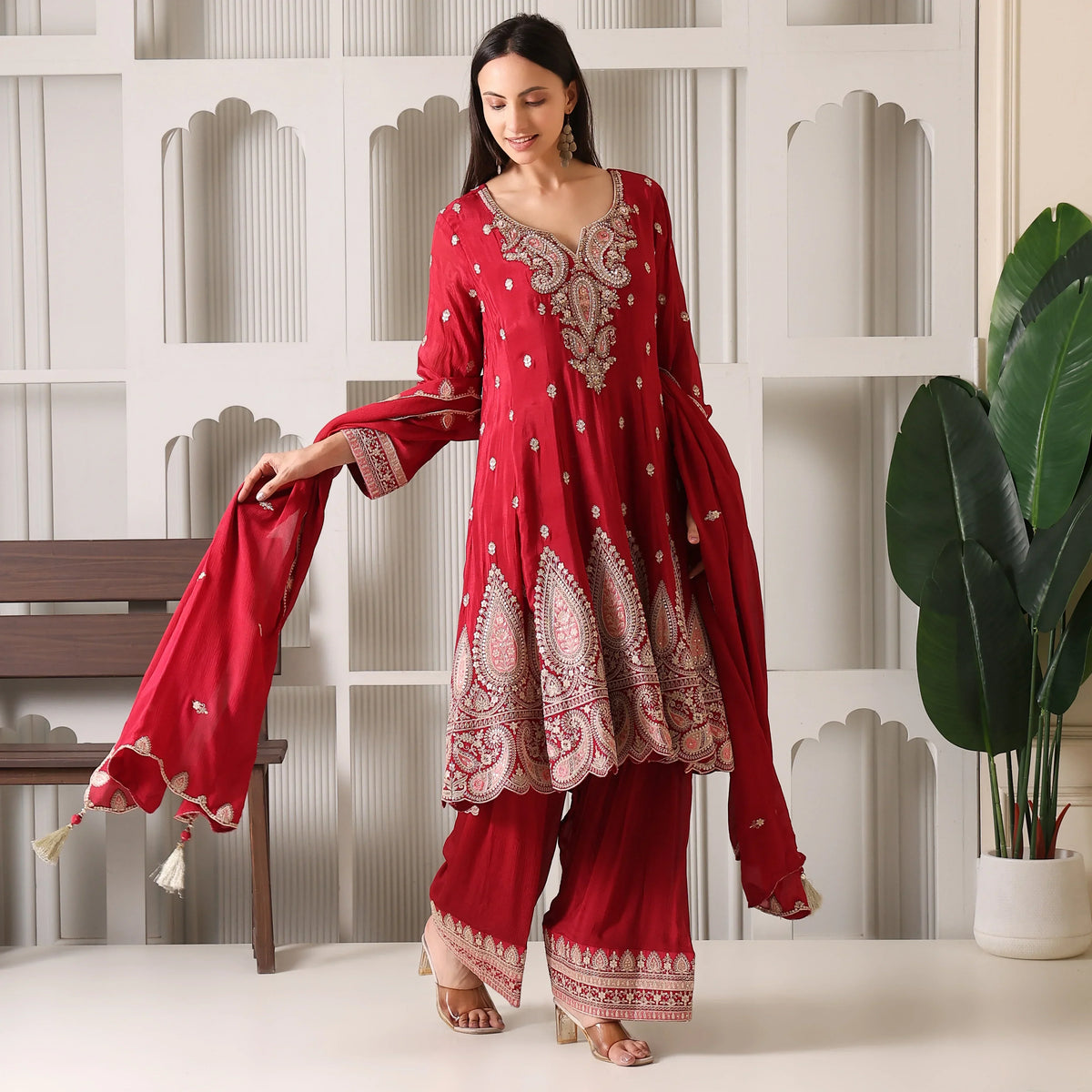 Woman in a red Banarasi Anarkali suit with dupatta, featuring intricate embroidery