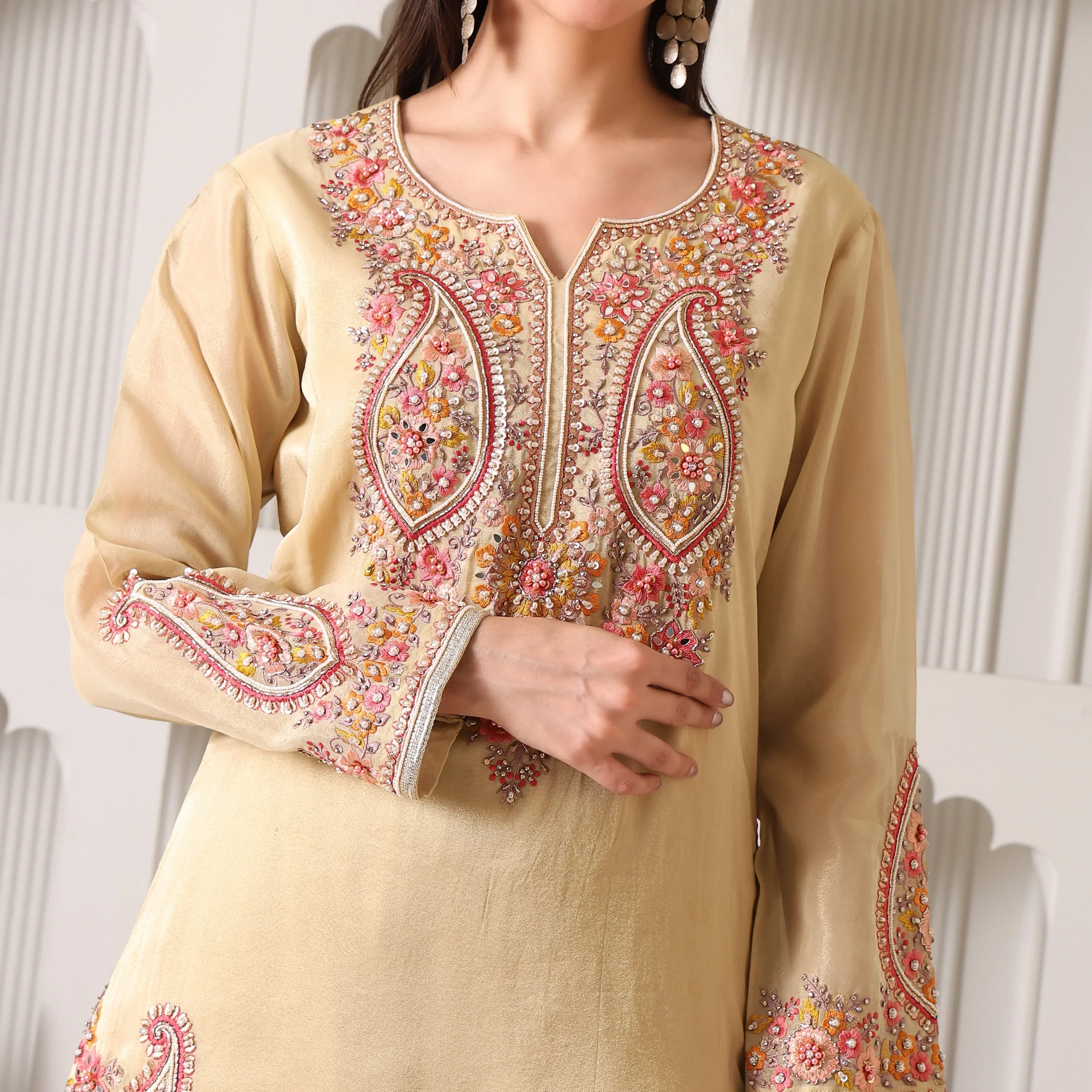 Beige ethnic suit with intricate floral embroidery, long sleeves, and festive detailing