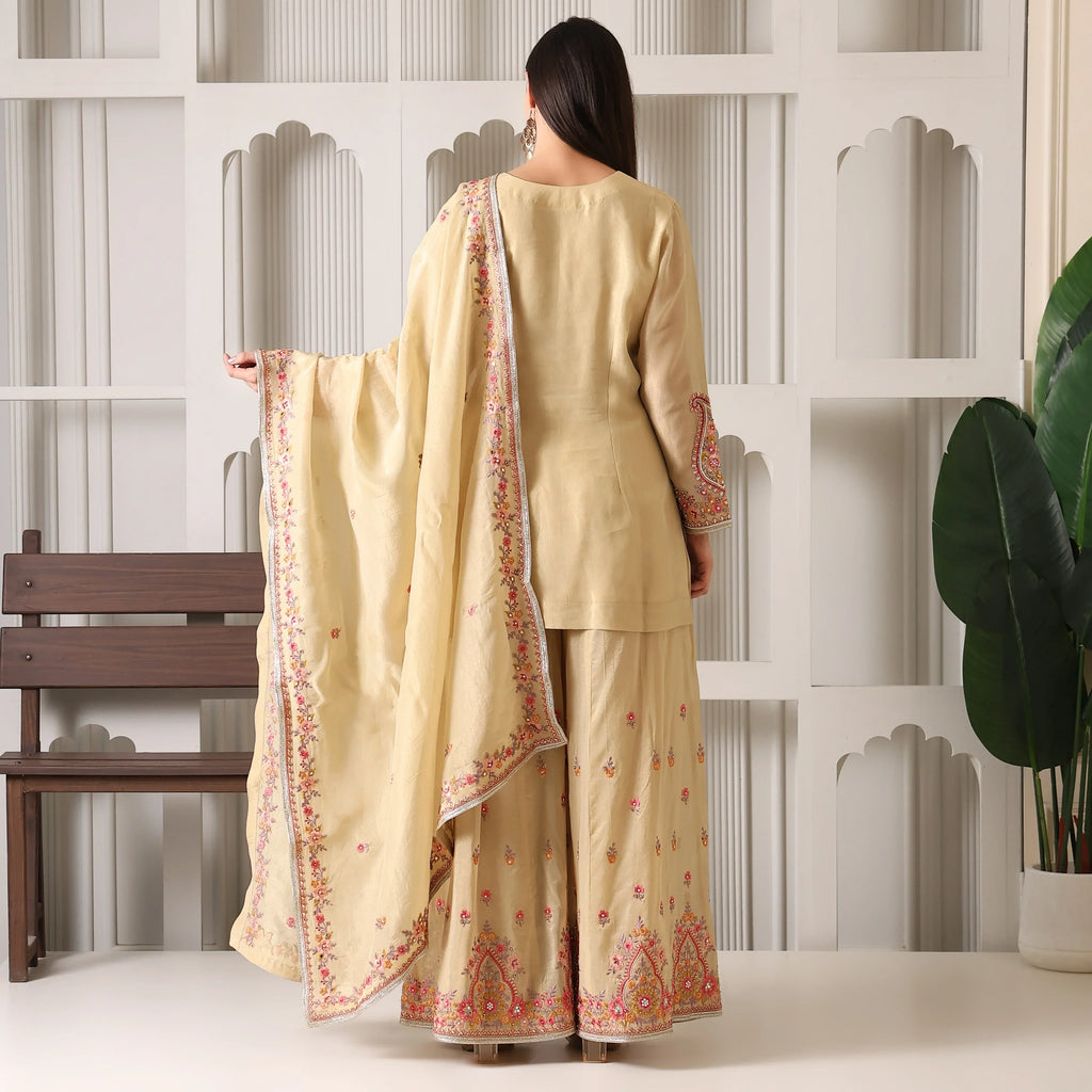Woman in beige embroidered ethnic suit with dupatta, wide-leg pants, festive wear