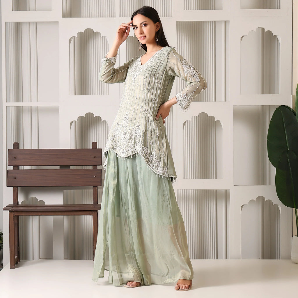 Woman wearing mint green embroidered Anarkali suit with wide pants, festive ethnic wear