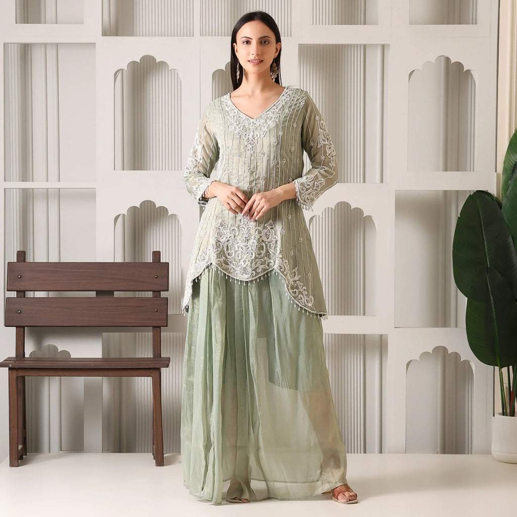Woman in pastel green embroidered ethnic kurta and palazzo set, standing indoors