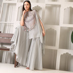 Woman in grey ethnic designer suit with flared pants and embellished cape detail