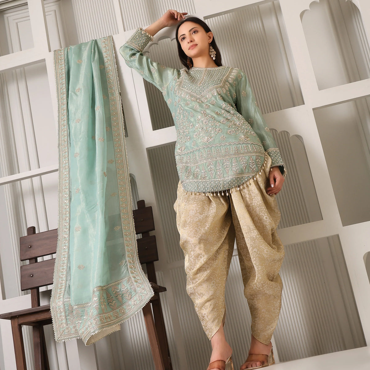 Woman in sage green embroidered kurta with gold Patiala pants and matching dupatta, ethnic wear