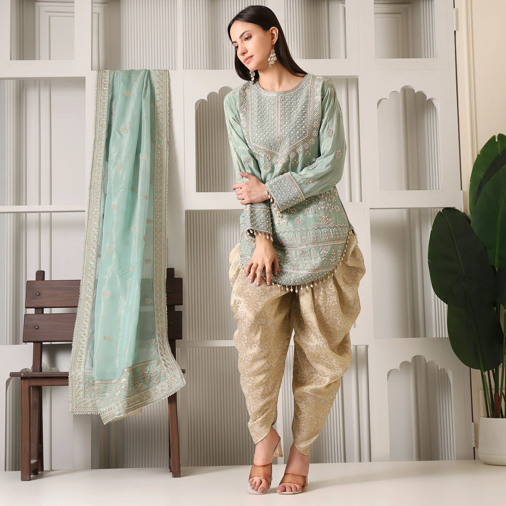 Woman wearing designer mint green embroidered kurta with gold dhoti pants and matching dupatta