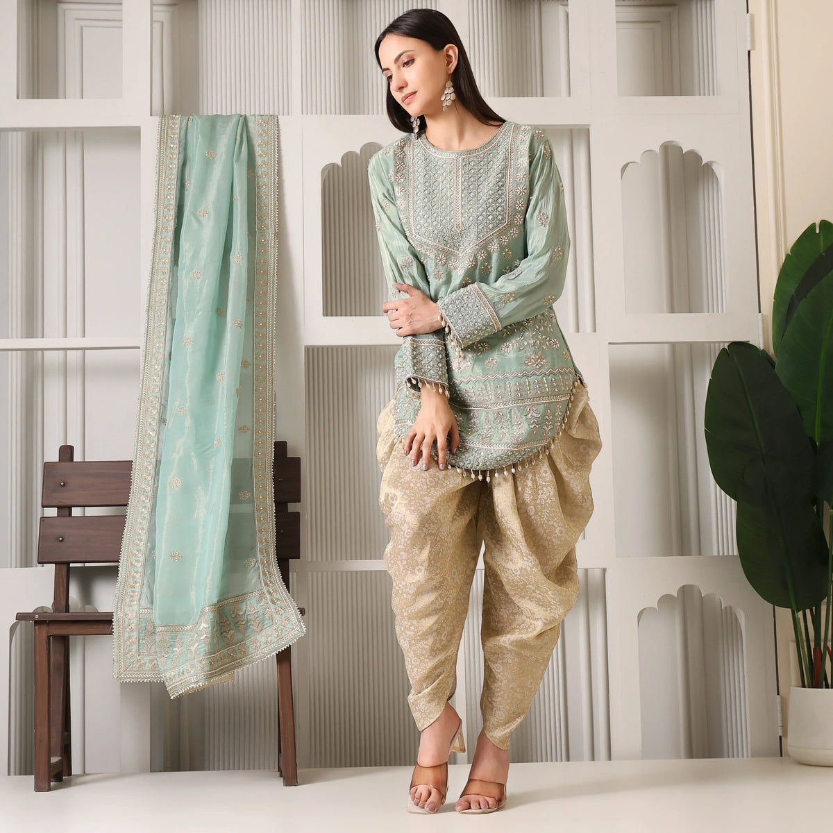 Woman wearing designer mint green embroidered kurta with gold dhoti pants and matching dupatta