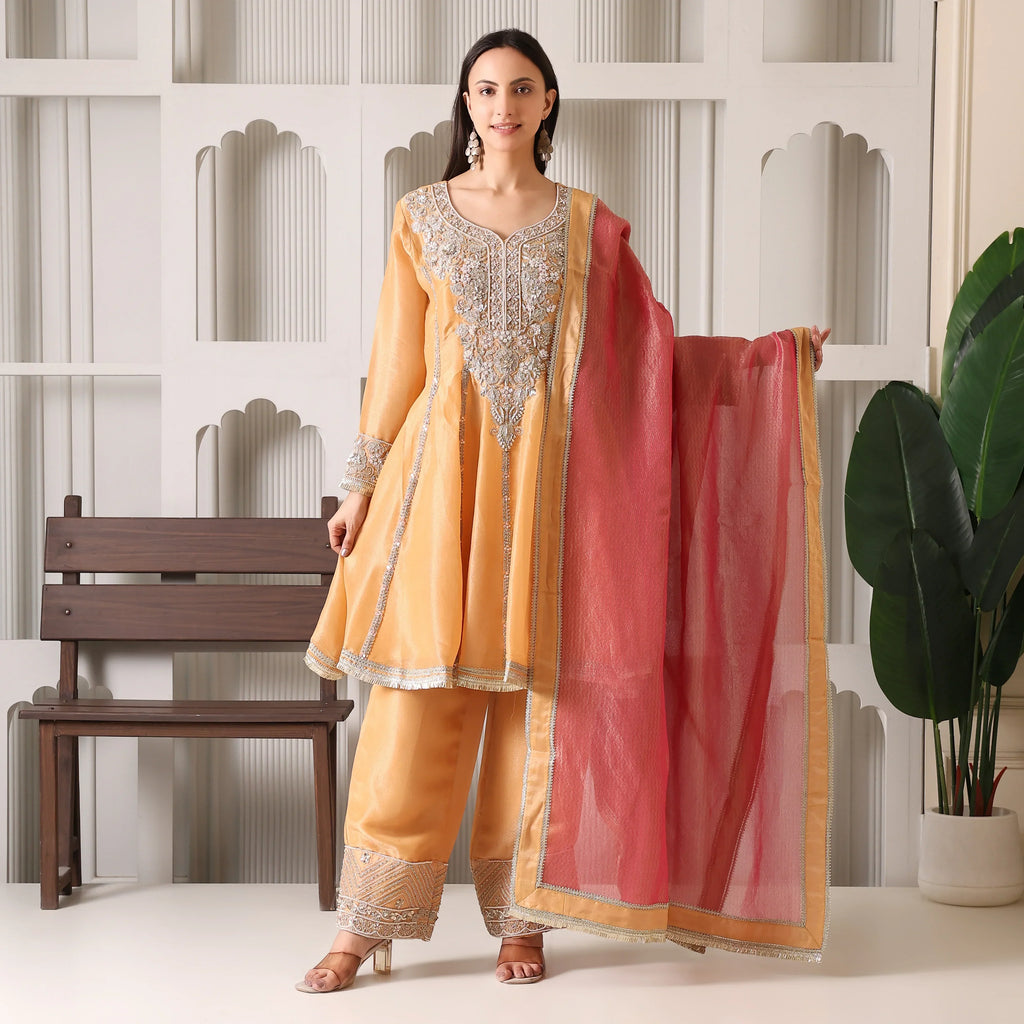 Woman in peach embroidered Anarkali suit with matching pants and sheer pink dupatta