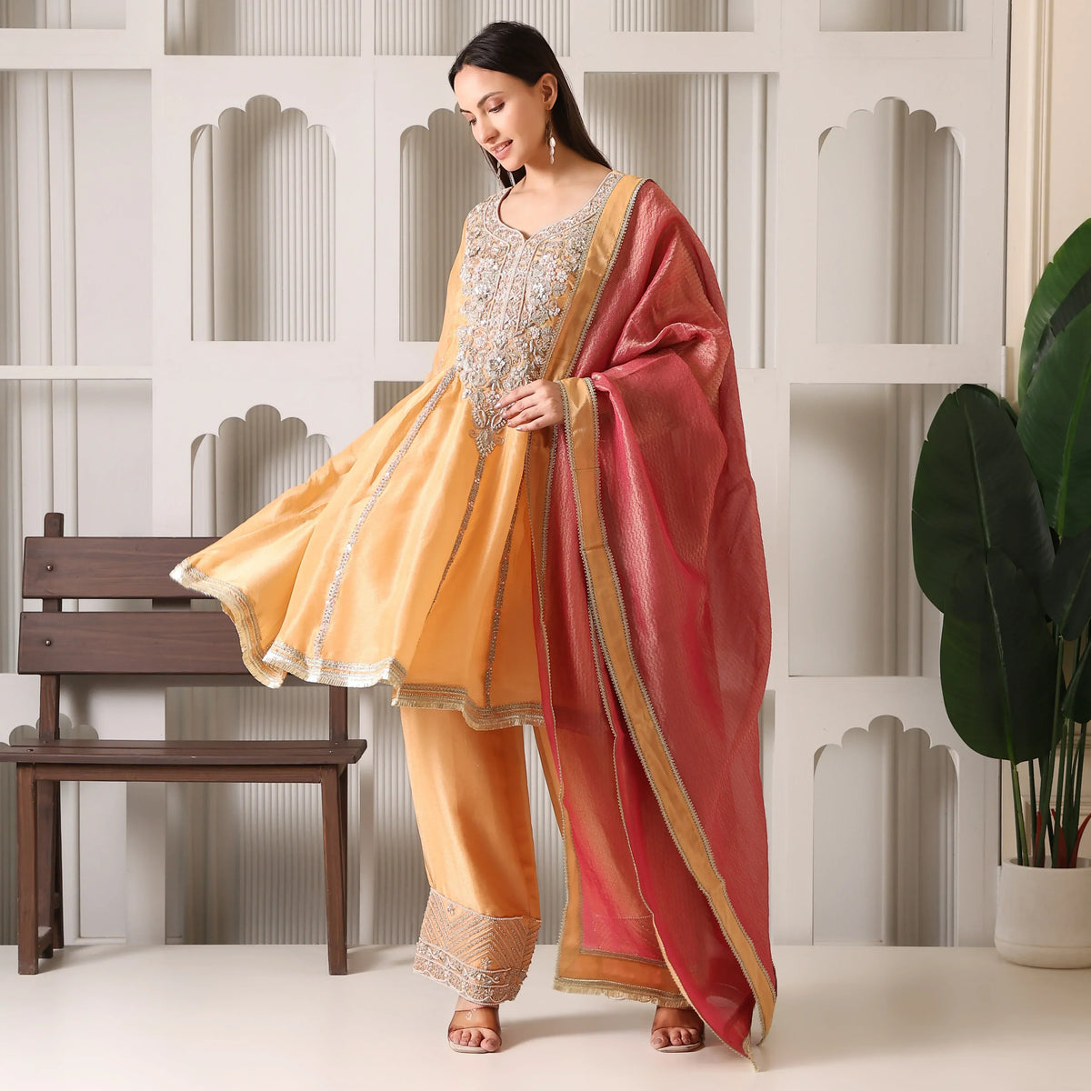 Woman in mustard yellow embroidered Anarkali suit with pink dupatta, festive ethnic wear