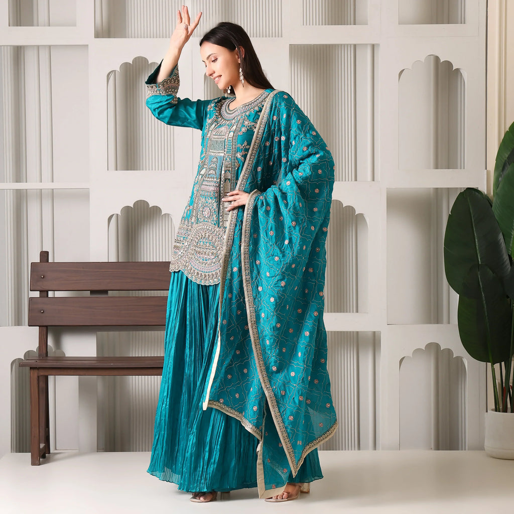 Woman in teal embroidered Anarkali suit set with dupatta, festive ethnic wear indoors