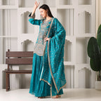 Woman in teal embroidered Anarkali suit set with dupatta, festive ethnic wear indoors