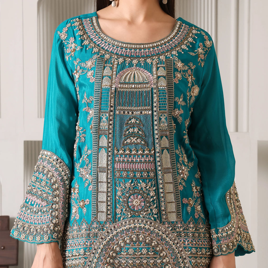 Teal blue ethnic kurta with intricate gold and silver zari embroidery, floral motifs, and detailed sleeves