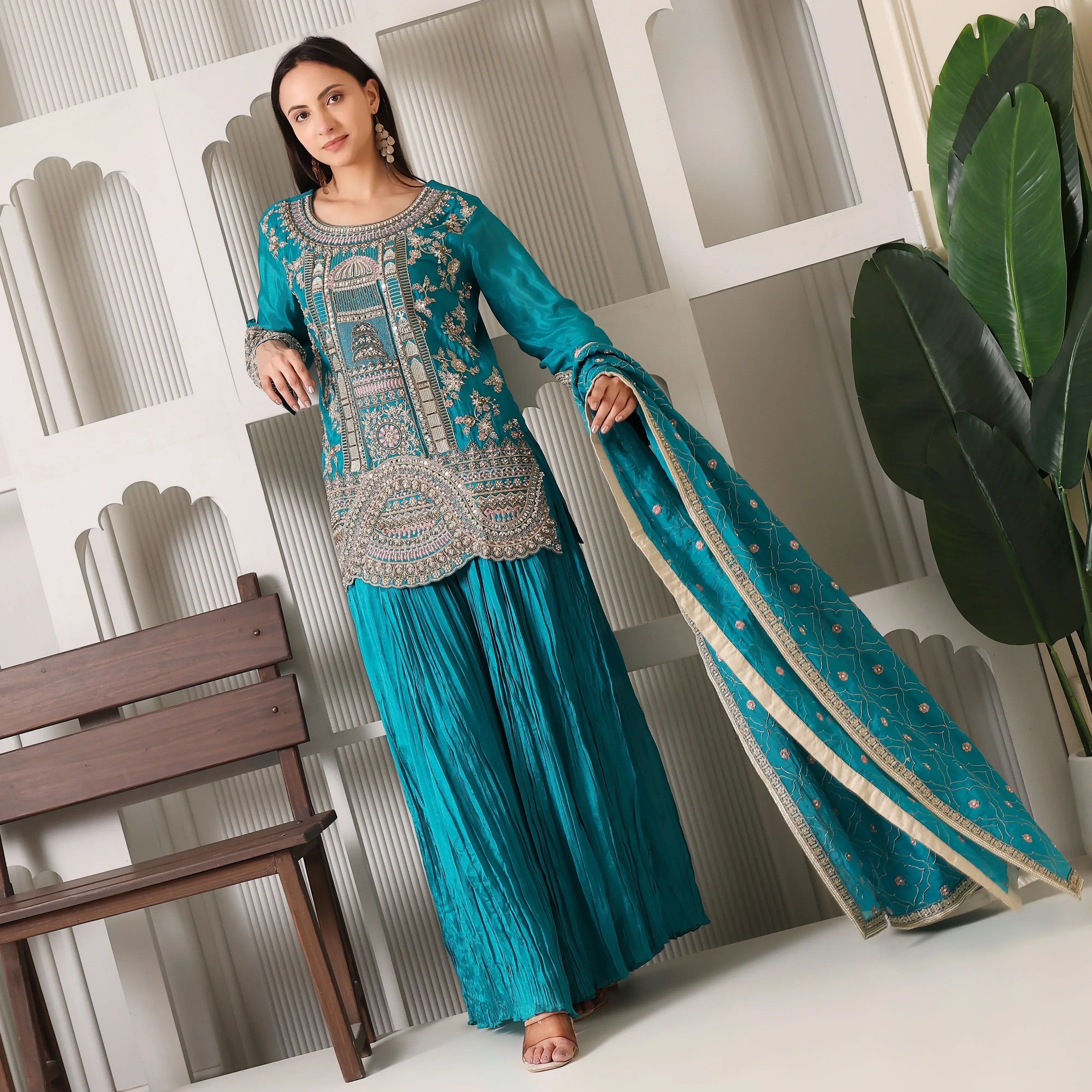 Woman in teal embroidered ethnic Anarkali suit set with dupatta, festive outfit indoor