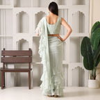 Back view of woman in pastel green ruffle saree with sleeveless blouse, modern ethnic outfit