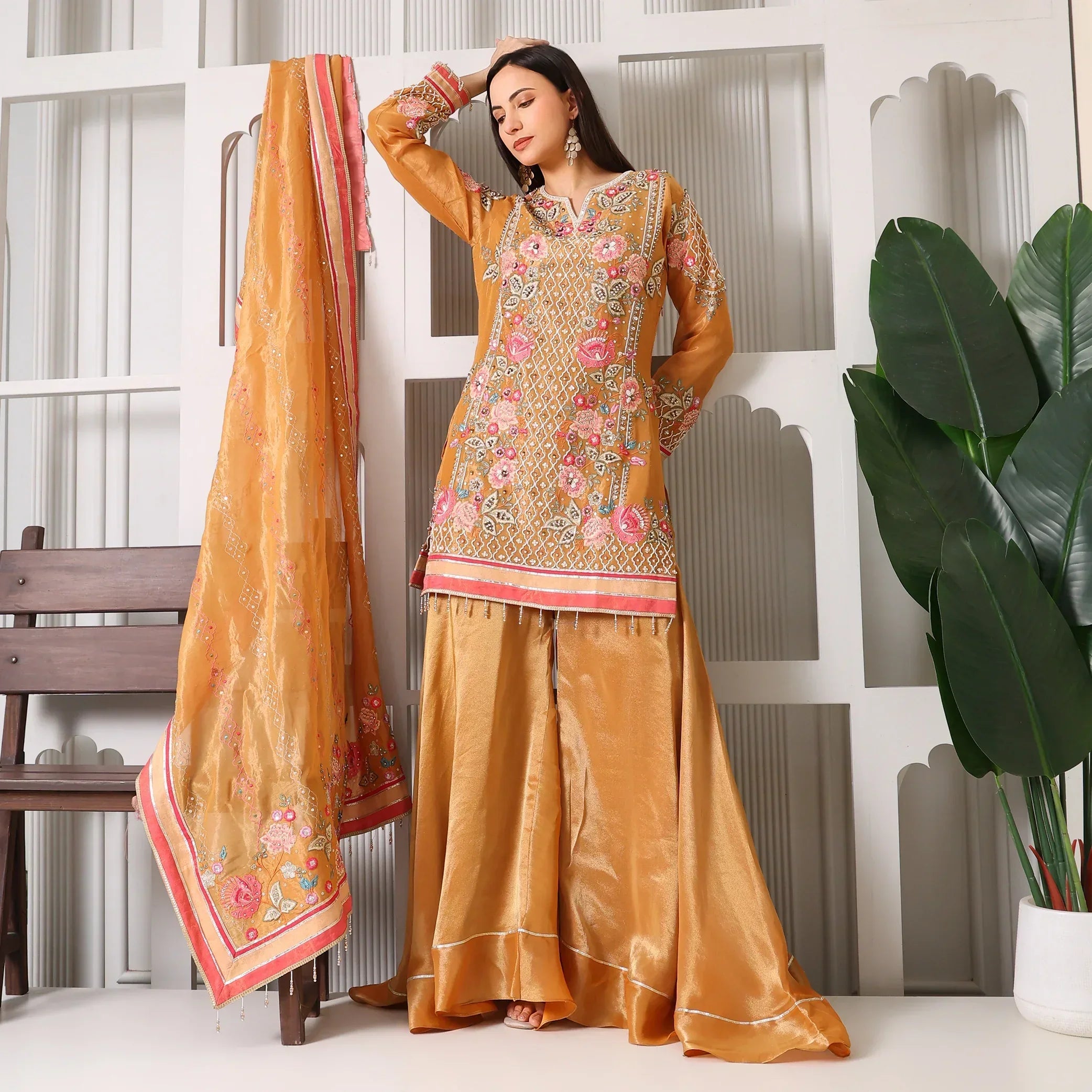 Woman in mustard yellow embroidered ethnic suit with palazzo pants and matching dupatta